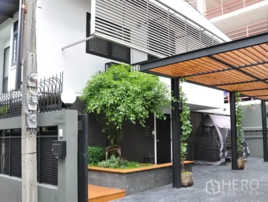 Detached House for rent in Watthana, Bangkok - Modern two-storey detached house with slatted sunshade, covered carport and small garden.