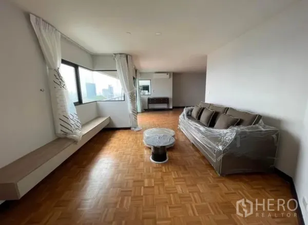 Condominium for rent - Long living area with sofa, window bench and wide city-facing windows.