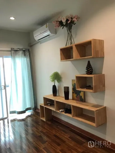 Townhouse for rent or sale in Phra Khanong, Bangkok - Wall-mounted wooden shelves, split air conditioner and sliding glass door with curtains.
