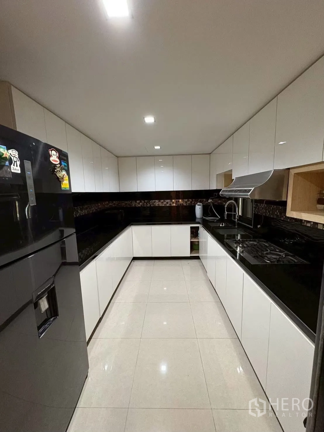 ทาวน์เฮาส์ for rent in Pathum Wan, Bangkok - ครัวสมัยใหม่รูปตัว U ตู้สีขาวและพื้นกระเบื้องเงา.