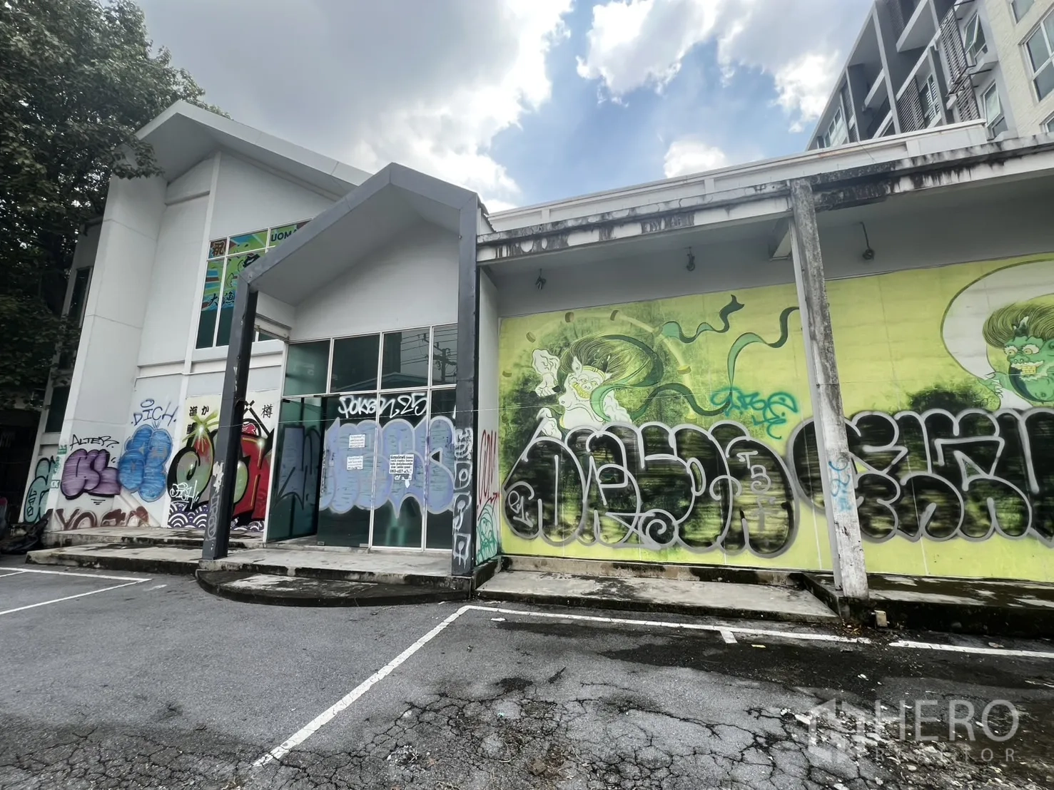 Retail Space for rent in Watthana, Bangkok - Side exterior wall with colorful graffiti art and marked parking bays.