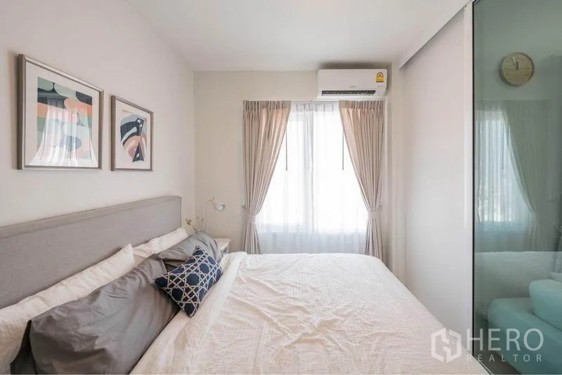 คอนโด ขายในHuai Khwang, Bangkok - ห้องนอนอบอุ่น เตียงขนาดใหญ่ แอร์ และหน้าต่างผ้าม่านโปร่ง