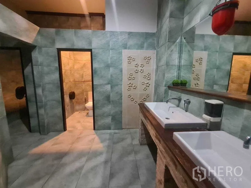 零售空间 出租在Watthana, Bangkok - 绿色瓷砖卫生间，配双长方形洗手盆、大镜面与两个独立厕间。