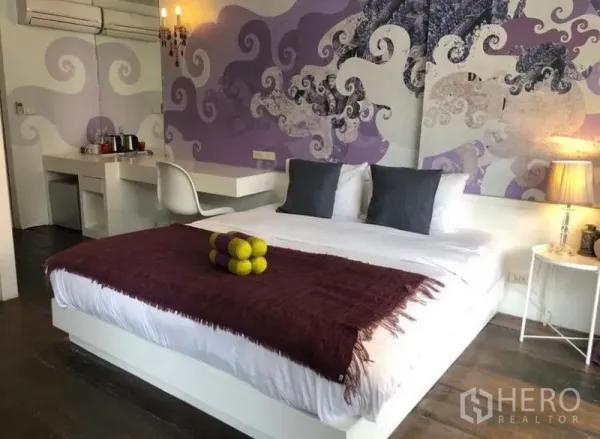 Townhouse for rent in Khlong Toei, Bangkok - Stylish bedroom with king bed, mural feature wall and built‑in desk.