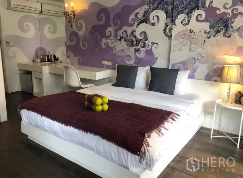 Townhouse for rent in Khlong Toei, Bangkok - Stylish bedroom with king bed, mural feature wall and built‑in desk.