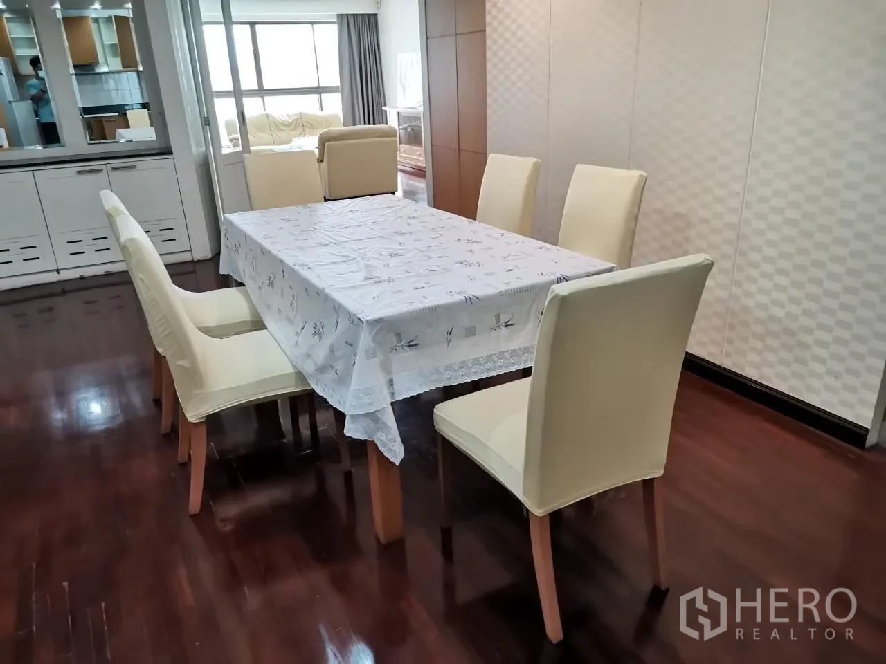 Condominium for rent in Phaya Thai, Bangkok - Six-seat dining table with cream chairs set on glossy hardwood floors near mirrored storage.