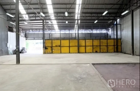 คลังสินค้า ให้เช่าในPak Kret, Nonthaburi - พื้นโกดังลึกไปยังประตูแผงสีเหลืองและโซนขนถ่ายด้านหลัง