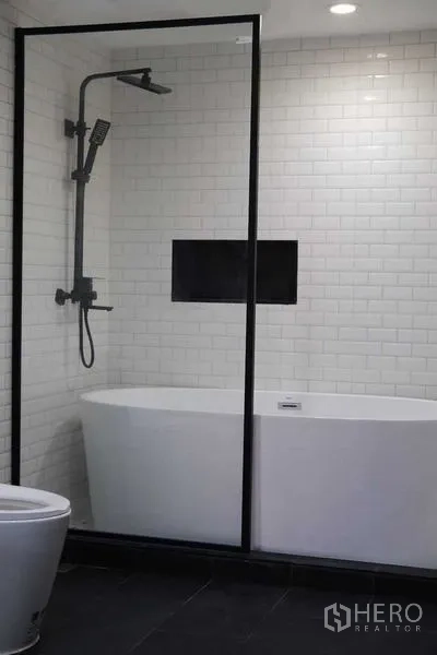 Condominium for rent in Bang Rak, Bangkok - Bathroom featuring a freestanding bathtub, walk-in shower and subway tiles.