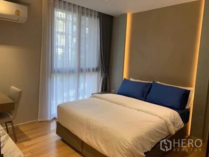 公寓 出租在Watthana, Bangkok - 次卧带双人床、书桌与大窗帘。