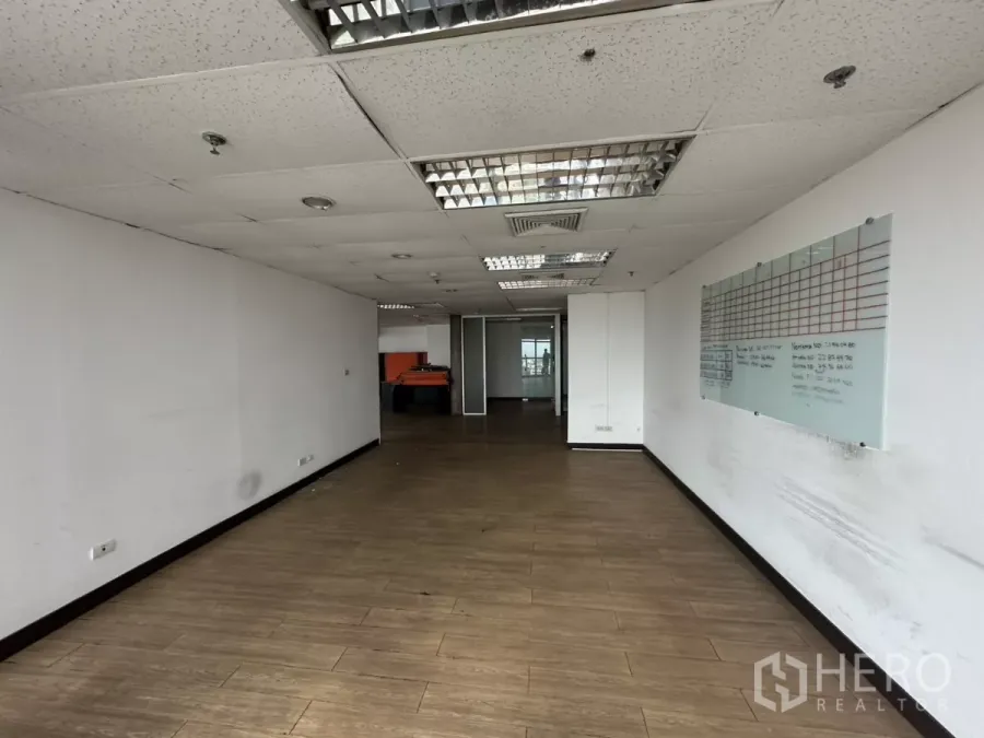 办公空间 出租在Watthana, Bangkok - 独立办公区，木纹地板、吊顶荧光灯，墙面设有计划看板。