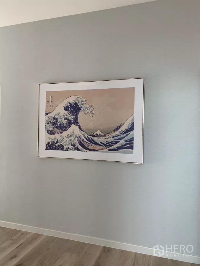 Detached House for rent in Bang Kapi, Bangkok - Hallway wall featuring framed wave artwork and wood flooring.