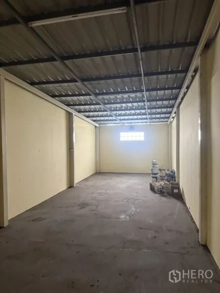 Shophouse for rent in Pak Kret, Nonthaburi - Upper-level storage room with metal sheet roof and small window.