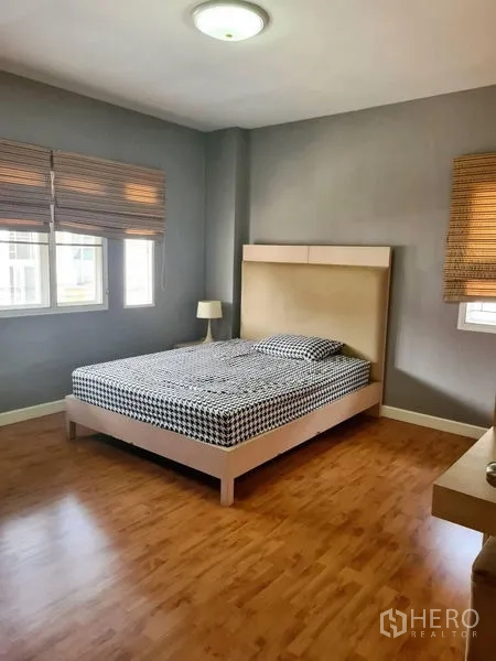 Detached House for rent in Sai Mai, Bangkok - Bright secondary bedroom with queen bed, wood flooring and corner windows.