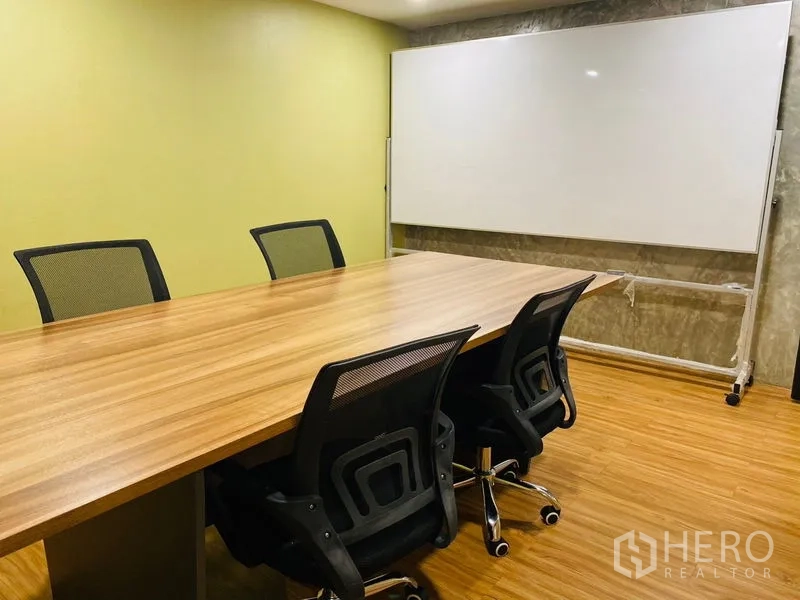 Office Space for rent in Bang Rak, Bangkok - Meeting room featuring a long table, mesh chairs and a mobile whiteboard.