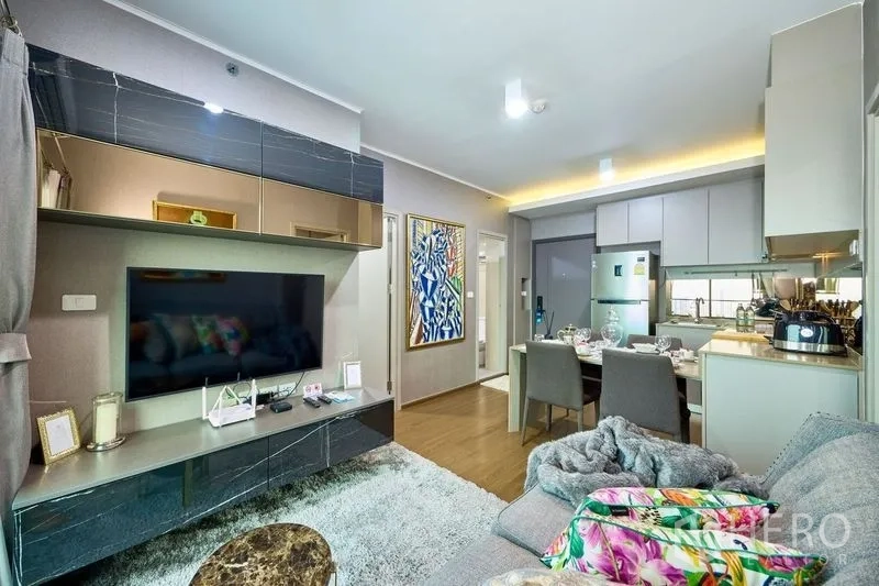 公寓 出租在Phra Khanong, Bangkok - 带大屏电视与储物的影音墙，面向沙发，连通餐厨区。