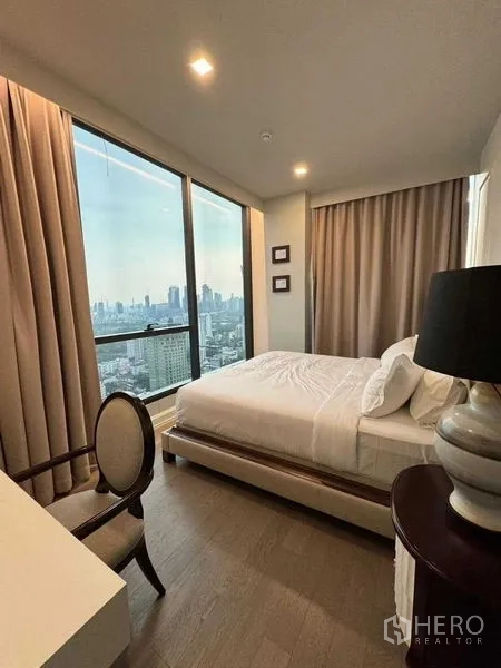 คอนโด ให้เช่าในWatthana, Bangkok - ห้องนอนหลัก กระจกมุมสองด้าน วิวเมืองพาโนรามา พร้อมโต๊ะทำงานและโคมไฟข้างเตียง.