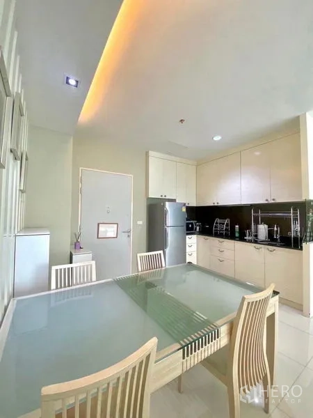 公寓 出租或出售在Bang Kapi, Bangkok - 紧邻厨房的用餐区，玻璃餐桌和高柜储物。