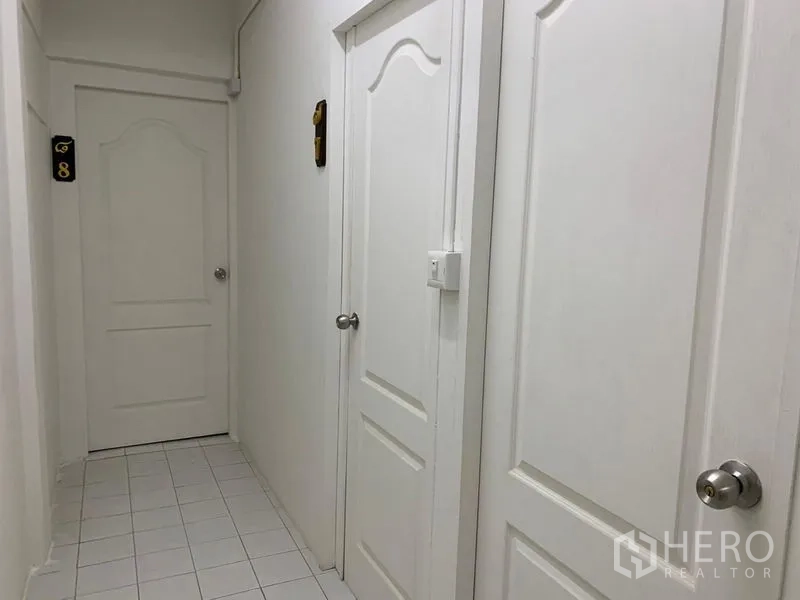 Shophouse for rent in Khlong Toei, Bangkok - Clean white corridor with multiple white panel doors and tiled floor.