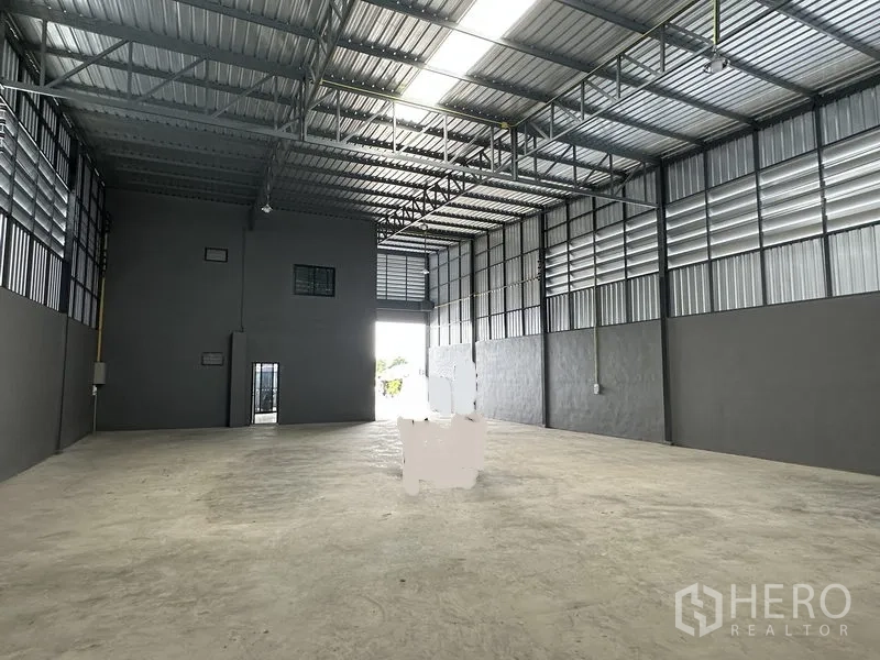 货栈 出租在Lam Luk Ka, Pathum Thani - 开放式仓库大厅，混凝土地面、通风百叶与大门入口