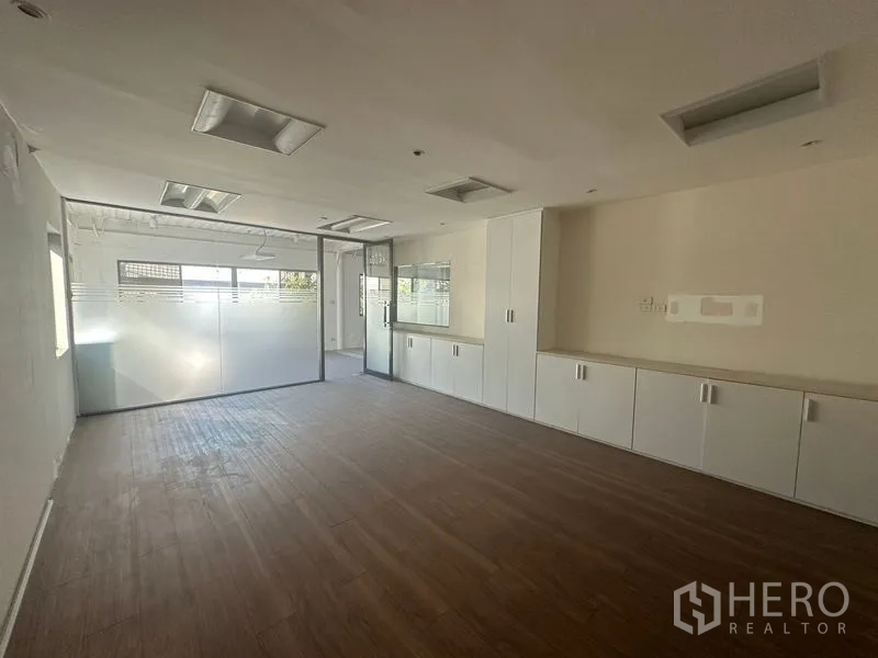 Warehouse for rent in Saphan Sung, Bangkok - Bright office with frosted glass partitions and storage cabinets.