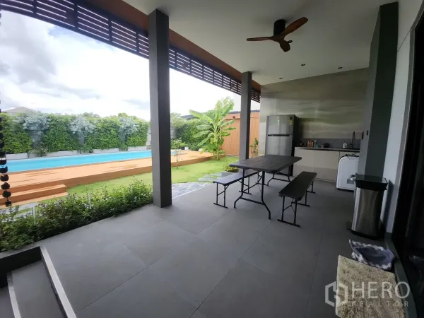 บ้าน ให้เช่าในBang Phli, Samut Prakan - เฉลียงกว้างพร้อมแพนทรีและชุดโต๊ะทานอาหาร มองเห็นสระและสวน