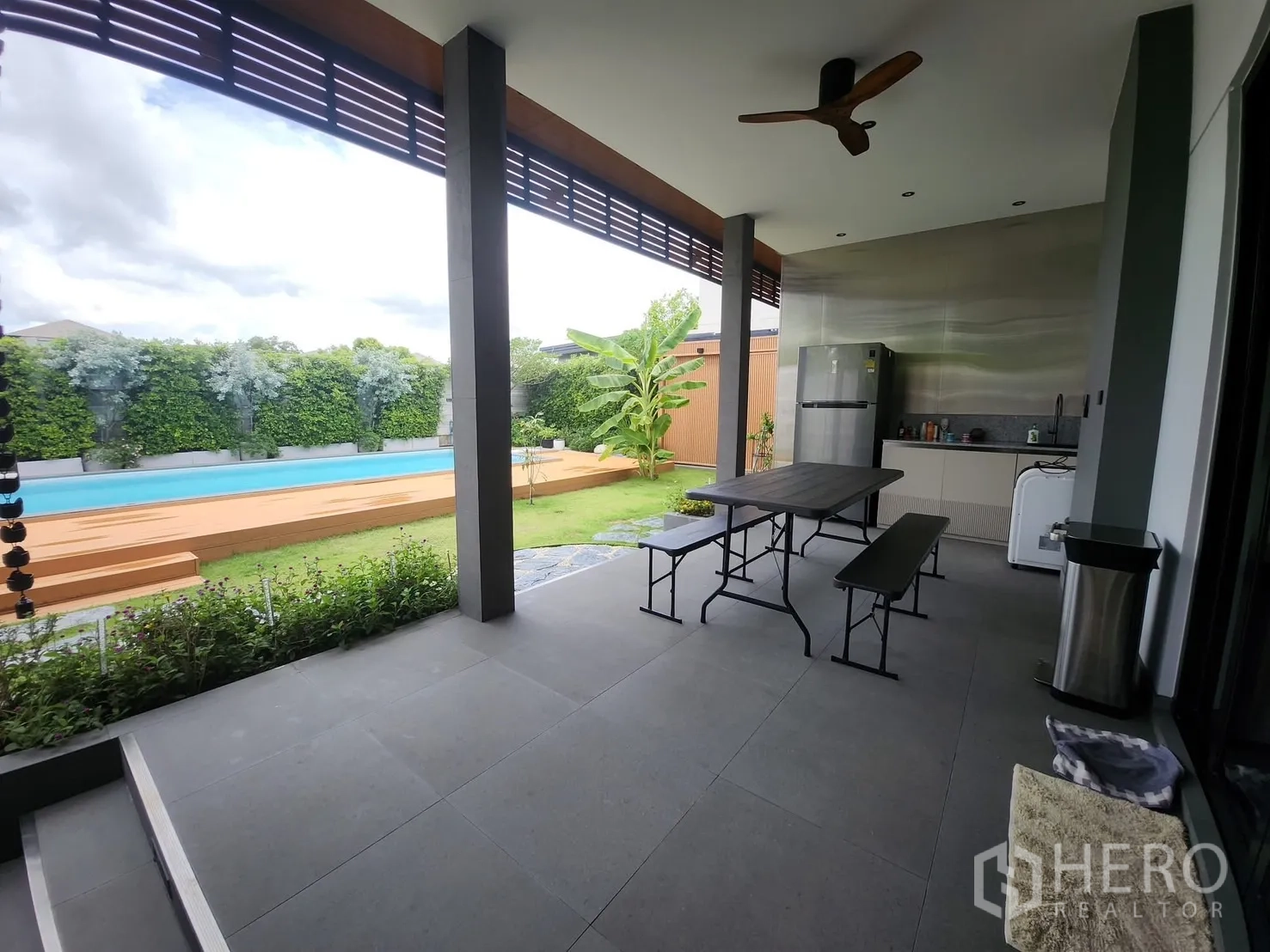 บ้าน ให้เช่าในBang Phli, Samut Prakan - เฉลียงกว้างพร้อมแพนทรีและชุดโต๊ะทานอาหาร มองเห็นสระและสวน