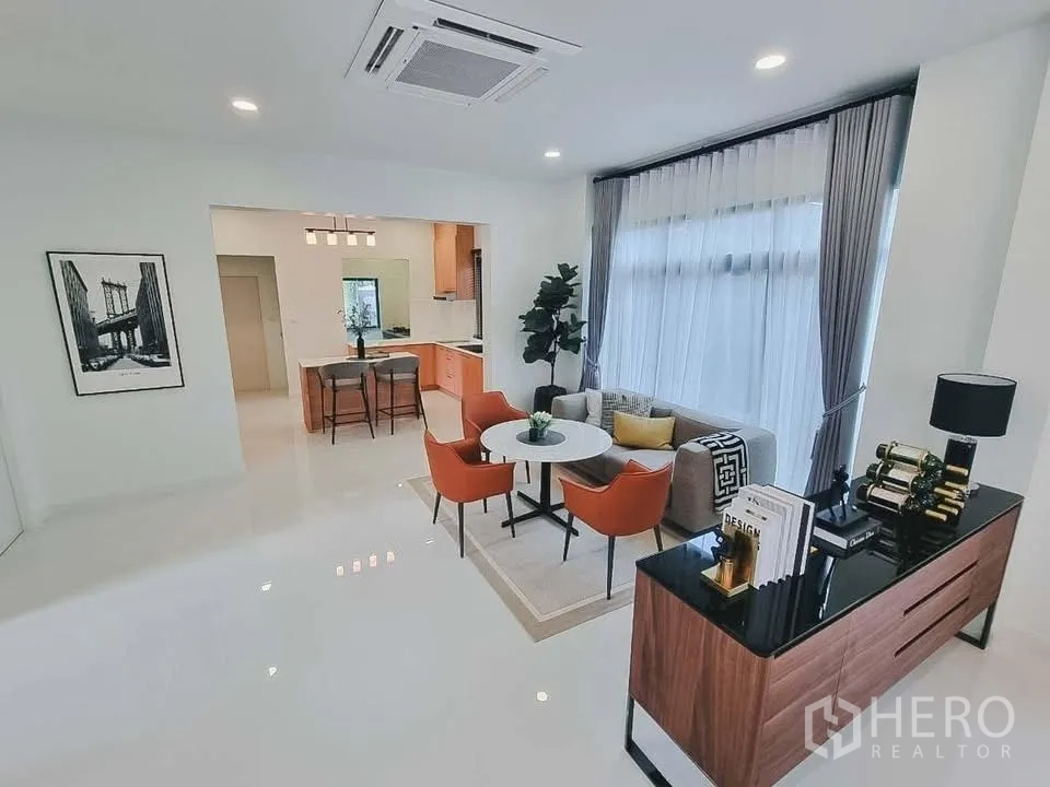 独栋房屋 for rent or sale in Bang Phli, Samut Prakan - 开放式家庭区，圆餐桌配橙色餐椅与吧台。