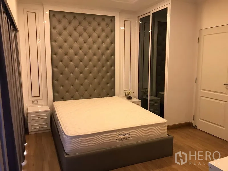 Detached House for rent in Bang Phli, Samut Prakan - Bedroom with tufted headboard feature wall, bed and mirrored wardrobe.