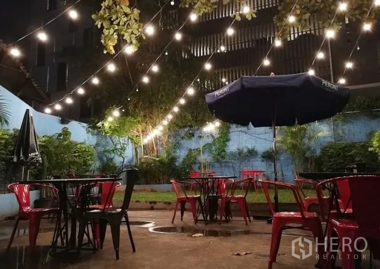 零售空间 出租在Watthana, Bangkok - 花园庭院夜景，串灯与红色金属椅桌