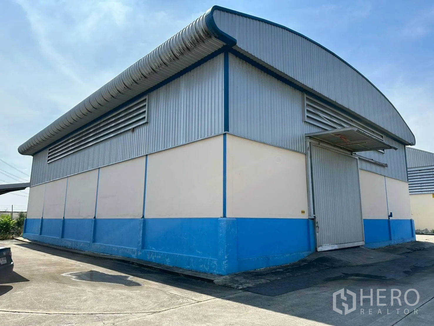 Factory for rent in Lat Lum Kaeo, Pathum Thani - Exterior of factory with loading bay door, driveway access and ventilation louvers.