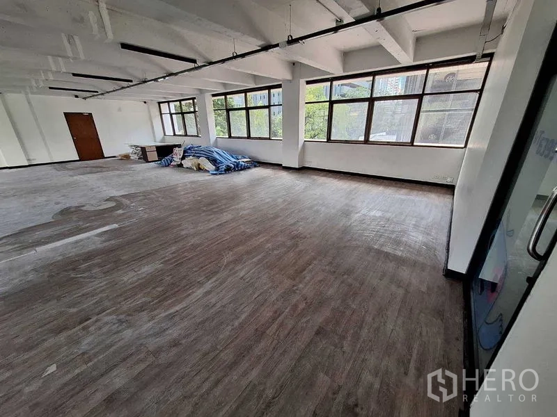 办公空间 出租在Watthana, Bangkok - 开放式工作区，角部大窗与玻璃入口门。