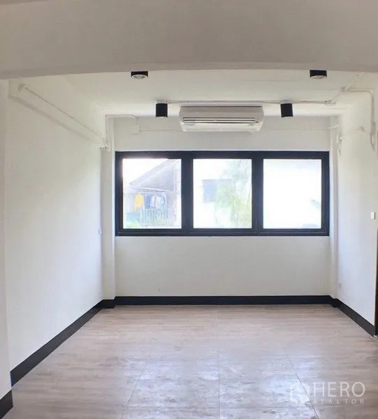 办公空间 出售在Ratchathewi, Bangkok - 紧凑型办公室，大尺寸黑框窗、壁挂空调与木纹地面。