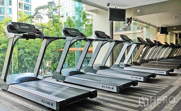 คอนโด ให้เช่าในPathum Wan, Bangkok - ฟิตเนสของคอนโด มีลู่วิ่งหลายเครื่องหันเข้ากระจก มองเห็นต้นไม้ภายนอก