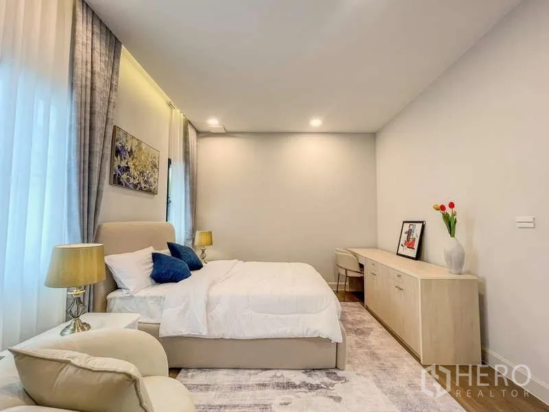 Detached House for rent in Saphan Sung, Bangkok - Bright guest bedroom with neutral decor, a bed and long sideboard.