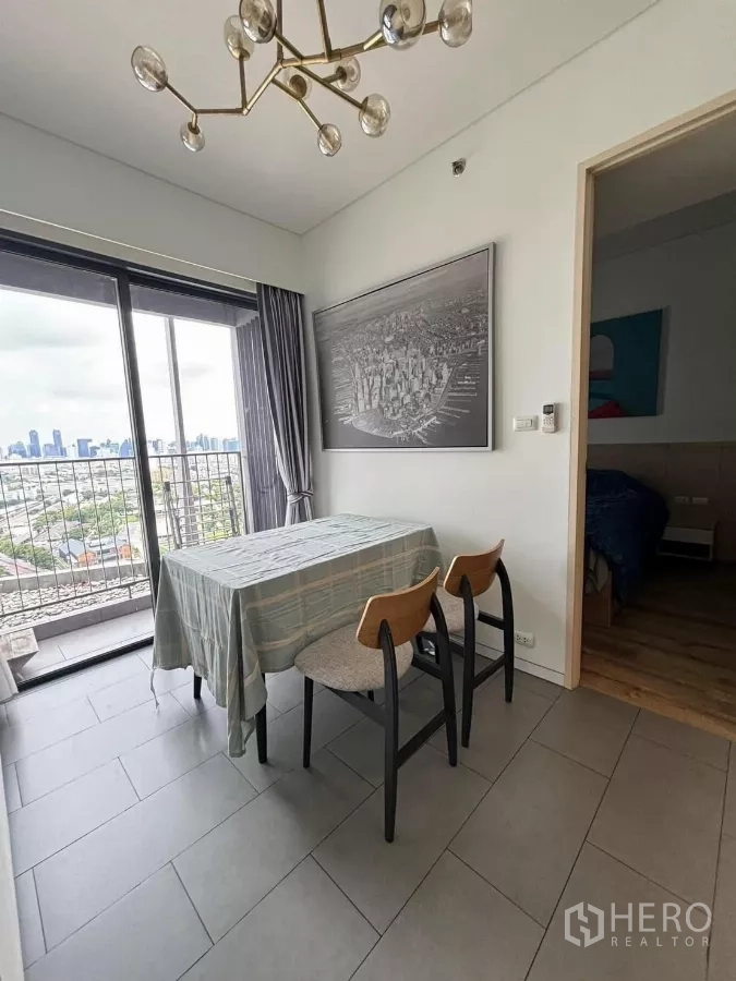 Condominium for rent or sale in Phaya Thai, Bangkok - Dining corner beside the balcony with skyline view and a modern brass chandelier.