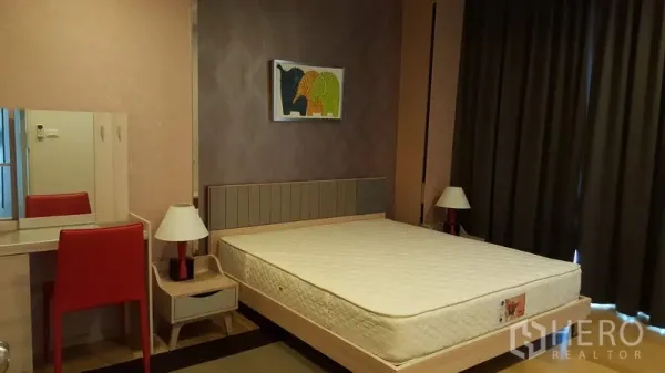 Condominium for rent in Phaya Thai, Bangkok - Cozy bedroom with upholstered headboard, blackout curtains and a dressing desk.