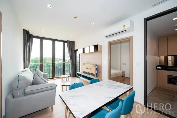 公寓 出租在Watthana, Bangkok - 开放式客厅视角，连接餐区、阳台与厨房入口。