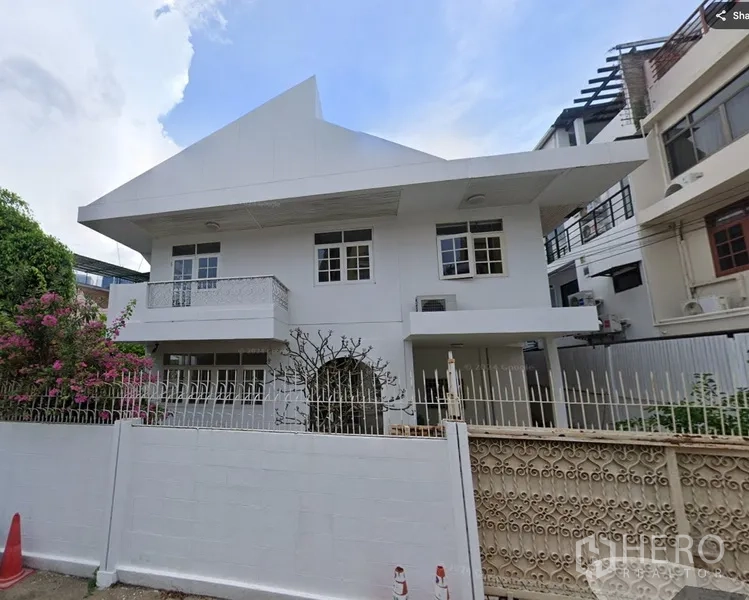独立式住宅 出租或出售在Sathon, Bangkok - 沙吞两层白色独栋住宅，尖顶屋檐与围栏前院。