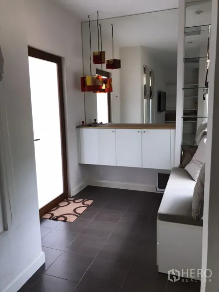 Detached House for rent or sale in Saphan Sung, Bangkok - Entry hallway with full-height mirror, floating cabinets and modern pendant lights.
