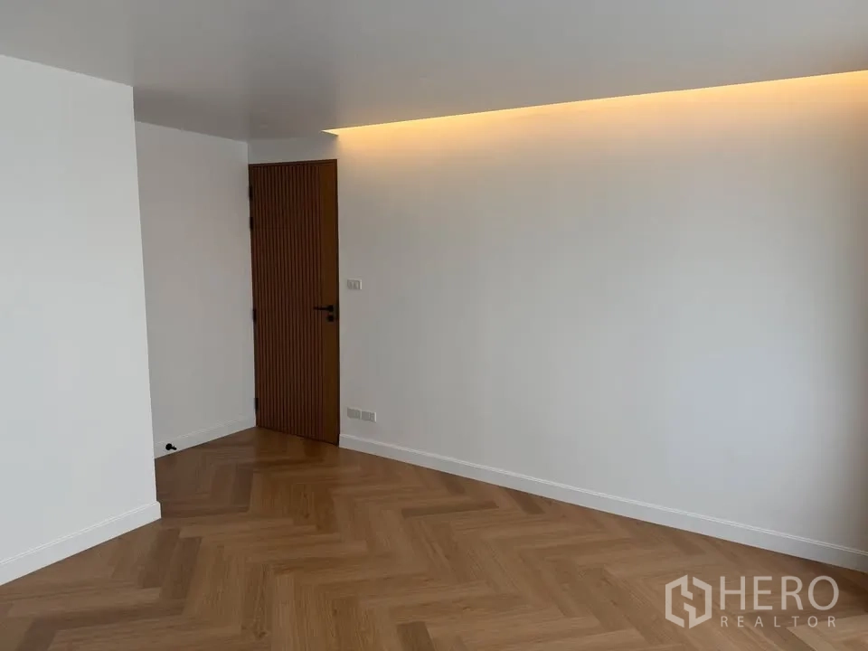 公寓 for rent in Watthana, Bangkok - 空房间，人字形木地板与天花灯带。