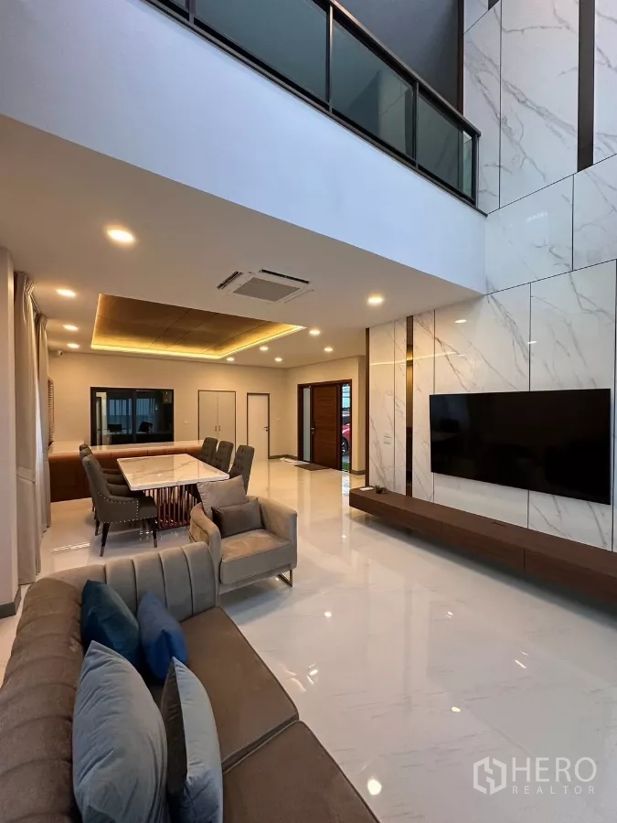 独立式住宅 出租在Bang Phli, Samut Prakan - 宽敞客餐厅，双层挑高与电视背景墙。