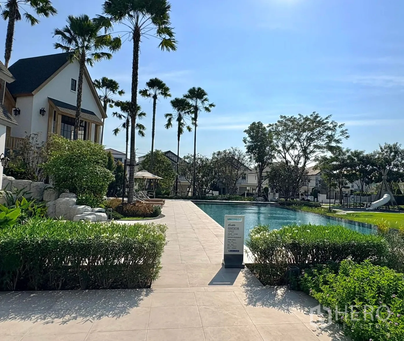 บ้าน for rent in Bang Phli, Samut Prakan - สระว่ายน้ำส่วนกลางข้างคลับเฮาส์ พร้อมต้นปาล์มและลานพักผ่อน