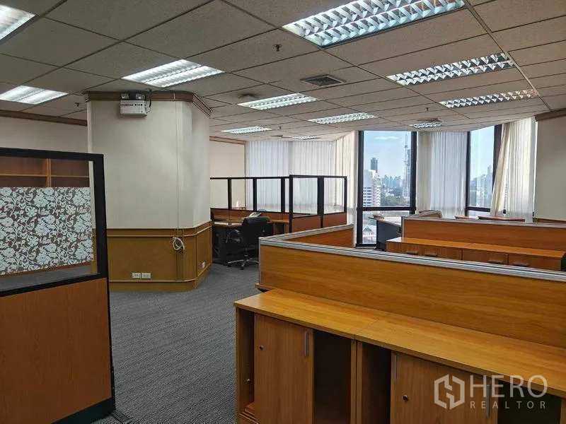 Office Space for rent in Din Daeng, Bangkok - Open-plan workspace with wood workstations and large windows showing a city view.