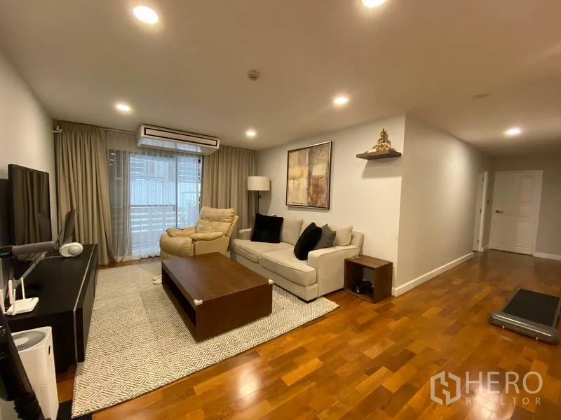 公寓 出租或出售在Watthana, Bangkok - 宽敞客厅，实木地板，沙发与躺椅、电视柜及落地窗帘。