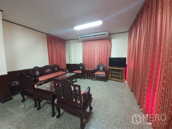 บ้าน ให้เช่า - ห้องนั่งเล่นพร้อมชุดเฟอร์นิเจอร์ไม้ ผ้าม่าน และเครื่องปรับอากาศ