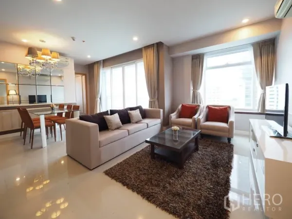 公寓 出租在Ratchathewi, Bangkok - 开放式客餐厅，沙发组、茶几、地毯与镜面墙，自然采光充足。