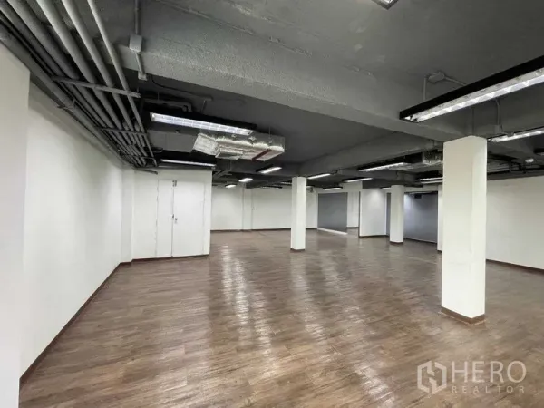 Office Space for rent in Ratchathewi, Bangkok - Large workspace with pillars, vinyl wood flooring and clean white walls.