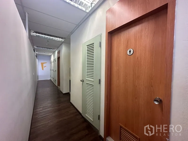 Office Space for rent in Bang Rak, Bangkok - Office hallway featuring a restroom door and louvered storage cupboards.