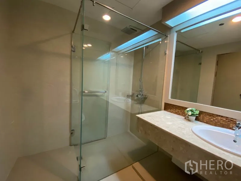 公寓 出租在Watthana, Bangkok - 现代卫浴，玻璃淋浴房与宽台面盥洗区。