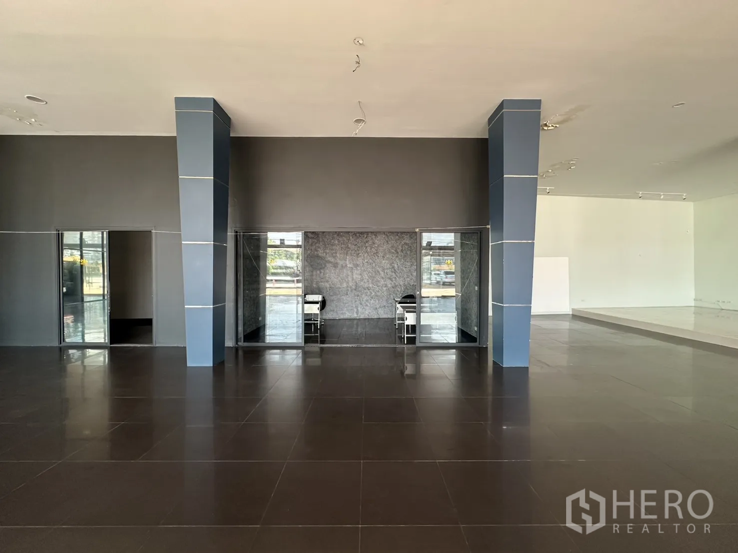 Showroom for rent in Suan Luang, Bangkok - Central columns framing glass offices within a wide open sales area.